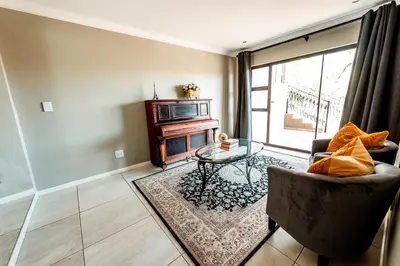 a living room with a couch and a table at Château La Mer Exclusive Guesthouse & Spa in Hartbeespoort