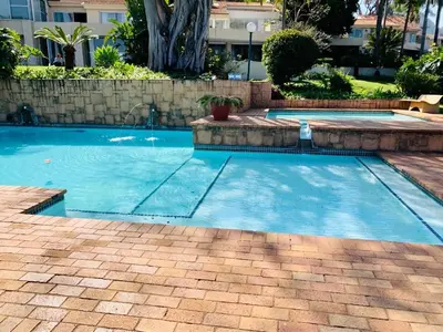 a swimming pool with blue water in a yard at Kosmos, Hartbeespoort in Hartbeespoort