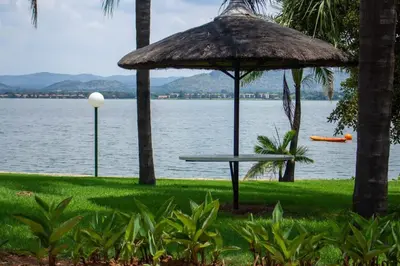 a picnic table with an umbrella next to the water at Kosmos, Hartbeespoort in Hartbeespoort