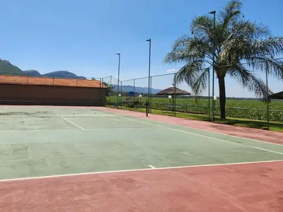 a tennis court with a palm tree in the background at Kosmos, Hartbeespoort in Hartbeespoort