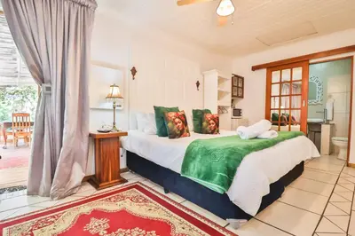 a bedroom with a large bed with green pillows at Snooze-A-Lot Guesthouse in Secunda