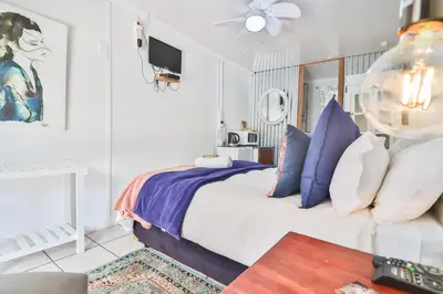 a bedroom with a bed with blue and white pillows at Snooze-A-Lot Guesthouse in Secunda