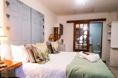 a bedroom with a white bed with pillows on it at Snooze-A-Lot Guesthouse in Secunda