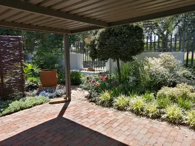 a patio under a pergola with a garden at Jasmine Guest Cottage in Benoni
