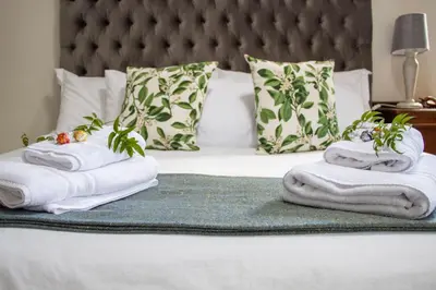 a bed with towels and plants on top of it at Jasmine Guest Cottage in Benoni