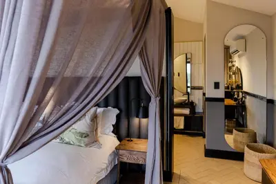 a bedroom with a bed with a canopy at Kruger Shalati - Train on The Bridge & Garden Suites in Skukuza