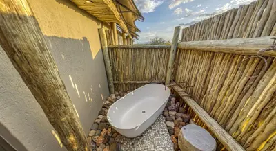 a bathroom with a toilet in the side of a building at Imagine Africa Luxury Tented Camp in Balule Game Reserve