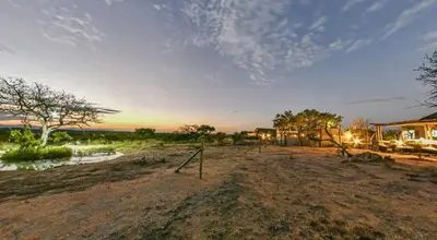 a playground in the middle of a field with a house at Imagine Africa Luxury Tented Camp in Balule Game Reserve