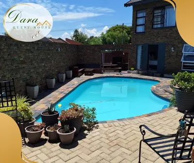 a swimming pool with potted plants next to a building at Dara on Schabort street in Trichardt