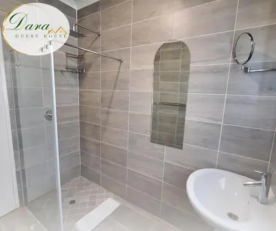a bathroom with a shower with a sink and a mirror at Dara on Schabort street in Trichardt