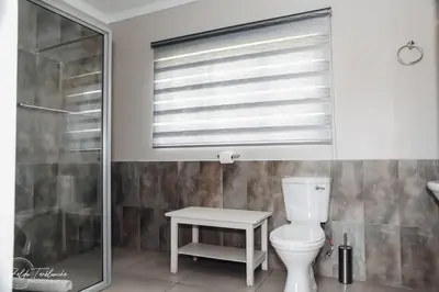 a bathroom with a white toilet and a window at Dara on Schabort street in Trichardt