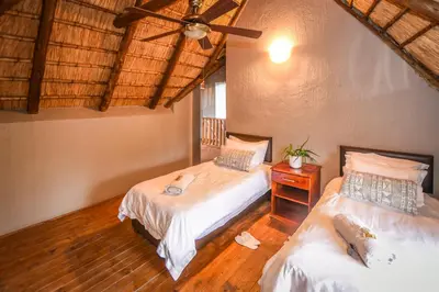 a bedroom with two beds and a ceiling fan at Khiza Bush Retreat in Hoedspruit