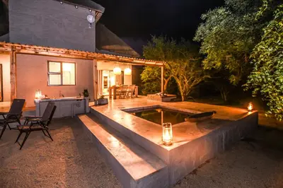 an outdoor pool with a table and chairs in a yard at Khiza Bush Retreat in Hoedspruit