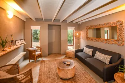 a living room with a couch and a mirror at Khiza Bush Retreat in Hoedspruit