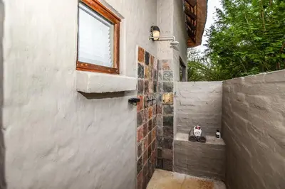 a bathroom with a shower with a window at Khiza Bush Retreat in Hoedspruit