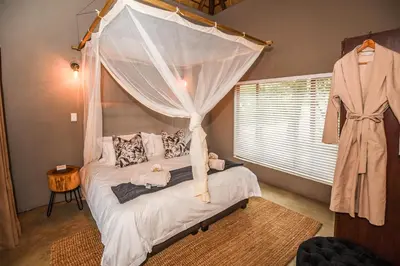a bedroom with a bed with a canopy at Khiza Bush Retreat in Hoedspruit