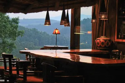 a bar in a restaurant with a view of the mountains at Tanamera Lodge in Hazyview