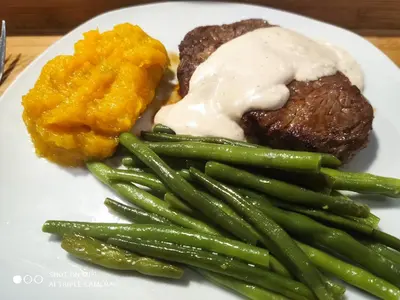 a plate of food with steak and green beans and mashed potatoes at Charis View Guest House in Belfast