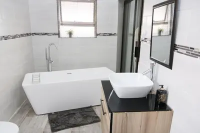 a white bathroom with a sink and a mirror at Charis View Guest House in Belfast