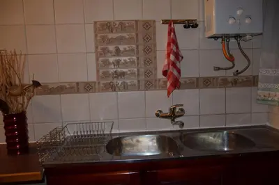 a kitchen sink with a dish drying rack next to it at Bushbaby Eden in Marloth Park