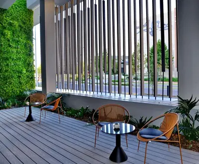 a patio with three chairs and a table and a window at Courtyard Hotel Waterfall City in Midrand