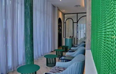 a row of green tables and benches in a room at Courtyard Hotel Waterfall City in Midrand