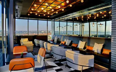 a restaurant with chairs and tables and windows at Courtyard Hotel Waterfall City in Midrand