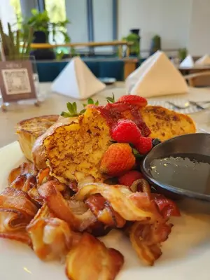 a plate of food with french toast and strawberries at Courtyard Hotel Waterfall City in Midrand