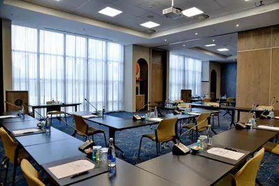 a conference room with tables and chairs and windows at Courtyard Hotel Waterfall City in Midrand