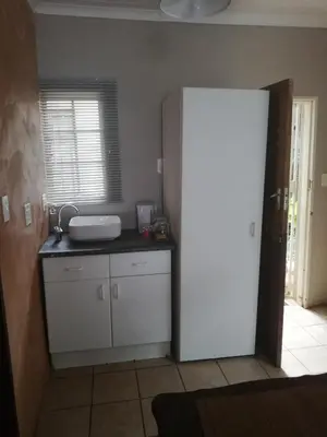 a kitchen with a white refrigerator and a window at A-Cody Place in Louis Trichardt