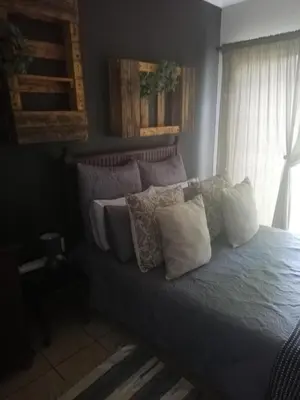 a bed with pillows on it in a bedroom at A-Cody Place in Louis Trichardt