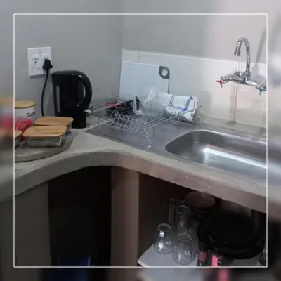 a kitchen counter with a sink and a dish rack at A-Cody Place in Louis Trichardt