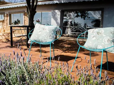 two chairs sitting on a patio in front of a house at Riverbed Africa in Lydenburg