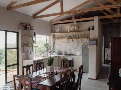 a kitchen with a wooden table and a dining room at Riverbed Africa in Lydenburg