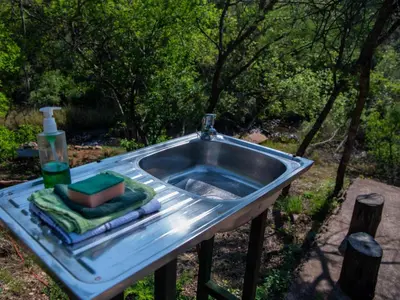 a sink with a bottle of soap and a towel at Riverbed Africa in Lydenburg