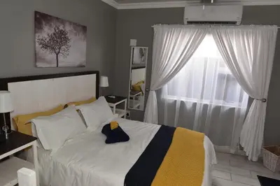 a bedroom with a white bed and a window at B&B 464 on 22nd Ave in Pretoria