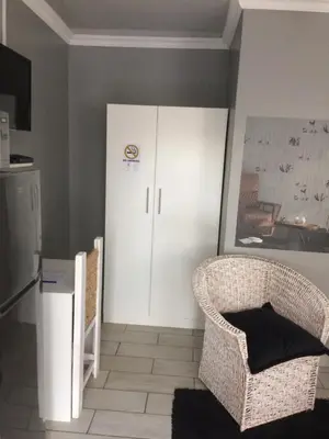 a kitchen with a white cabinet and a chair at B&B 464 on 22nd Ave in Pretoria