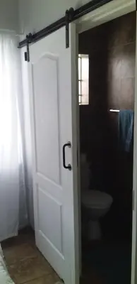 a bathroom with a white door and a toilet at B&B 464 on 22nd Ave in Pretoria