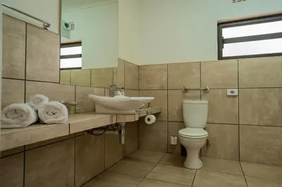 a bathroom with a toilet and a sink at Tshukudu Game Lodge in Hoedspruit