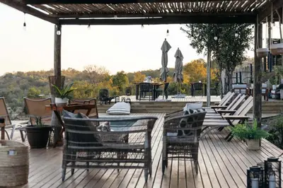 a wooden deck with a table and chairs on it at Isambane Camp in Balule Game Reserve