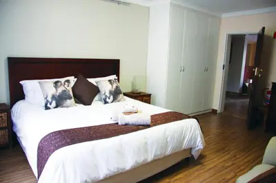 a bedroom with a bed with two dogs on the pillows at African BnB - The Boutique Experience in Benoni