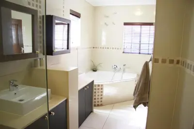 a bathroom with a tub and a sink and a bath tub at African BnB - The Boutique Experience in Benoni