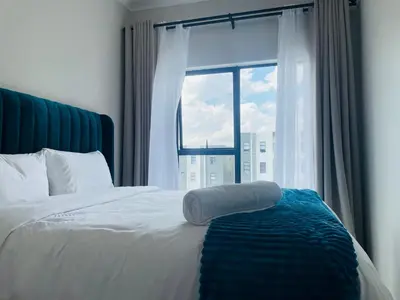 a bed with a towel on it in front of a window at Mikeys place On New: 2bed2bath no.1 with Free WiFiNetflix in Midrand