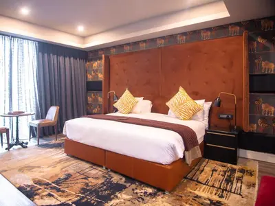 a bedroom with a large bed in a room at MGB Hotel at 2ten in Thohoyandou