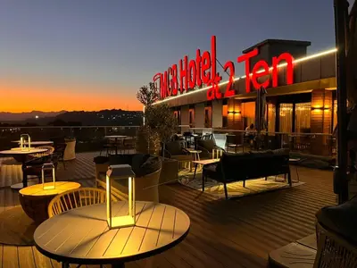 a restaurant with tables and chairs on a deck at night at MGB Hotel at 2ten in Thohoyandou