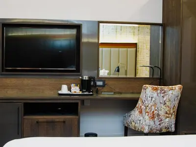 a room with a desk with a television and a chair at MGB Hotel at 2ten in Thohoyandou