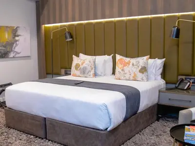 a hotel room with a large bed with pillows at MGB Hotel at 2ten in Thohoyandou