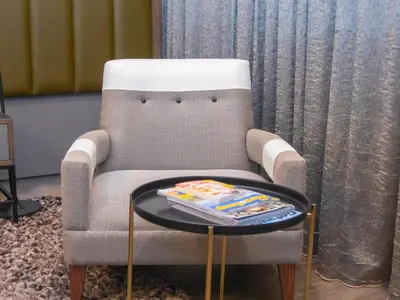 a living room with a chair and a table at MGB Hotel at 2ten in Thohoyandou