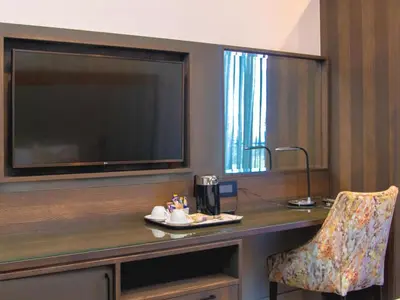 a room with a desk with a television and a chair at MGB Hotel at 2ten in Thohoyandou