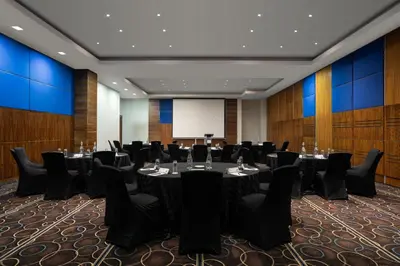 a conference room with tables and chairs and a whiteboard at Premier Hotel Midrand in Midrand